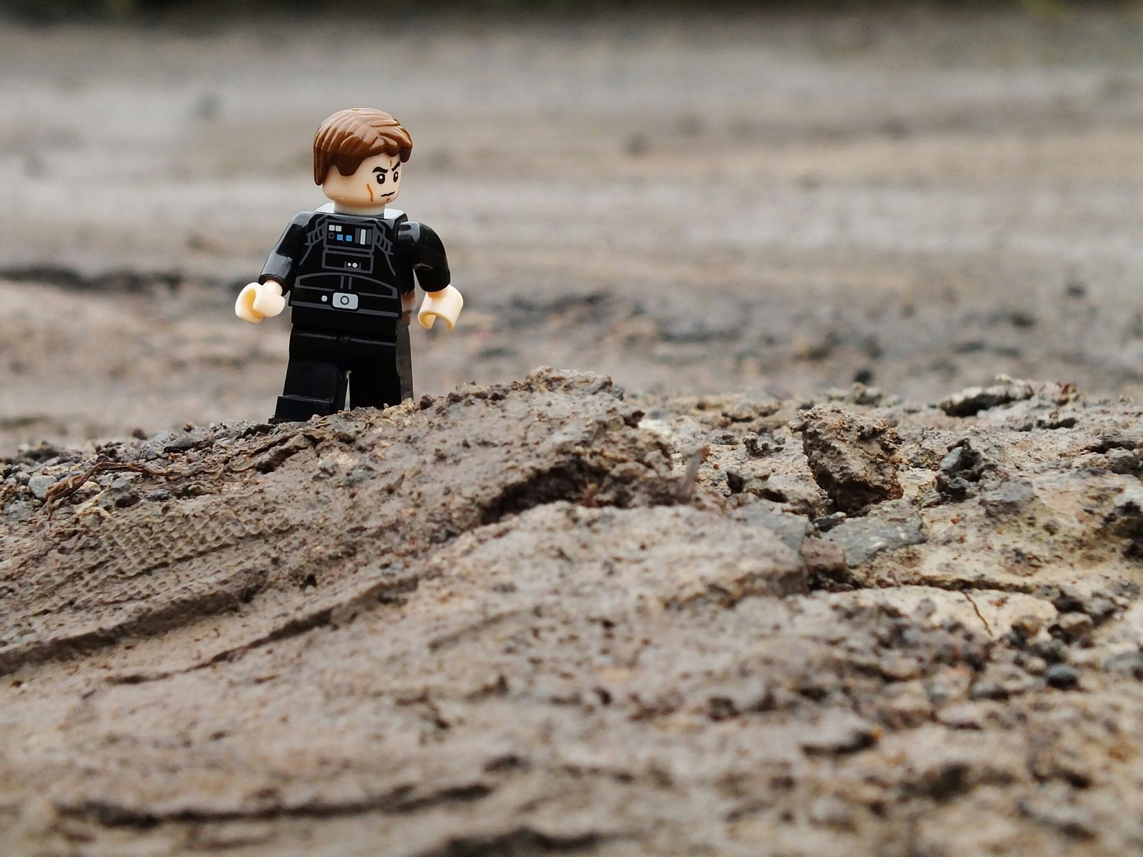 a lego man standing on top of a sandy beach